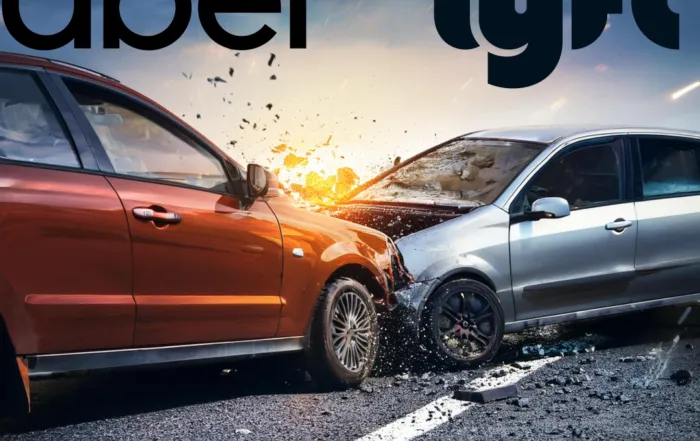 Two cars, one red and one silver, collide head-on on a paved road with visible damage and debris.